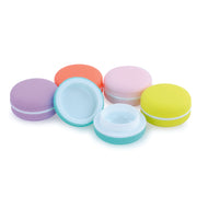 5 macaroons in different colours outside of packaging