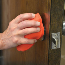 Charger l&#39;image dans la galerie, jar opener in use with a persons hand on a door knob
