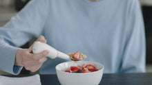Charger l'image dans la galerie, image of a hand holding the Liftware steady while eating cereal with barries